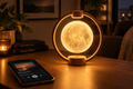 Magnetic levitation moon speaker with warm wood ring frame and glowing 3D moon sphere floating on a modern desk